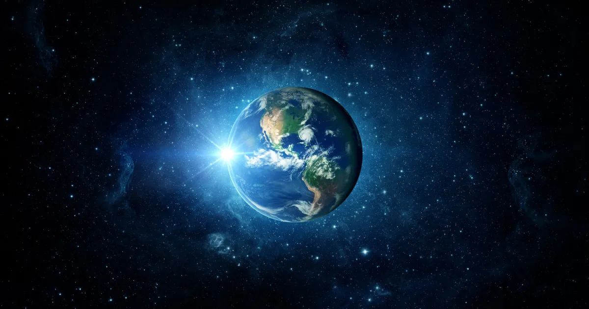 Jorden sett fra verdensrommet, med sollys som bryter fram bak planeten