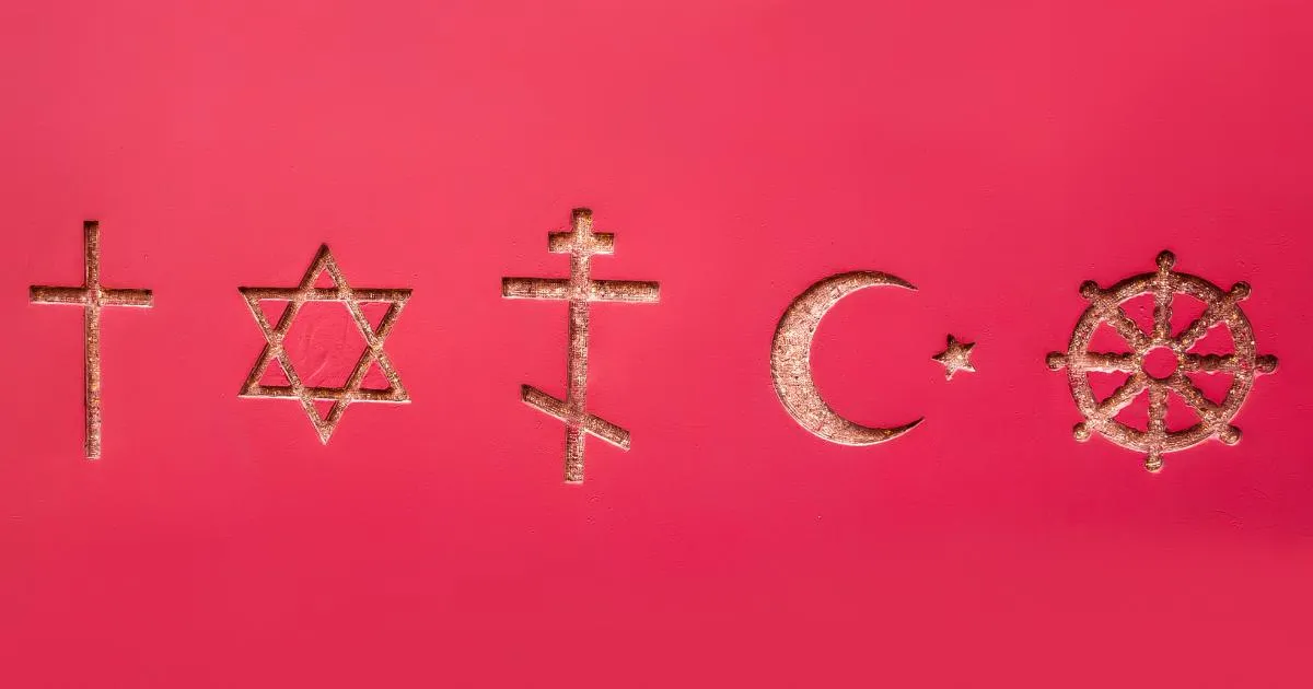 Symboler for ulike religioner, blant dem kors, davidsstjerne, halvmåne og dharmahjul, på rød bakgrunn