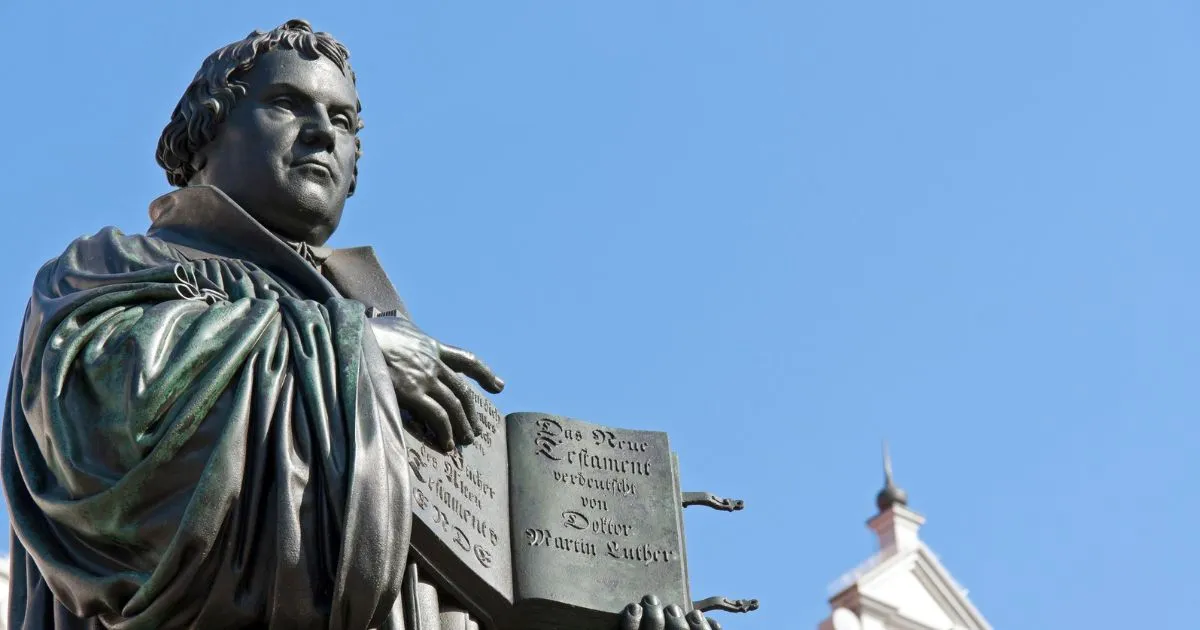 Statue av Martin Luther med en oppslått bok